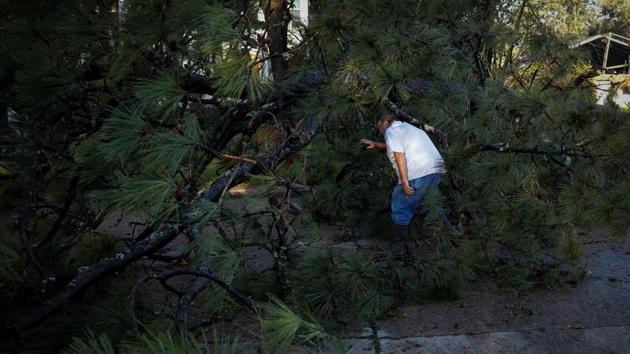 A man tries to clear a tree that was felled after Hurricane Delta made landfall in Jennings, Louisiana on October 10. About 600,000 of the state’s electric customers, 25% of the total, were without power on October 10. However, restoration was progressing faster than it did after Laura because Delta’s winds were less damaging to the infrastructure, Governor John Bel Edwards told Reuters. (Marco Bello / Reuters)