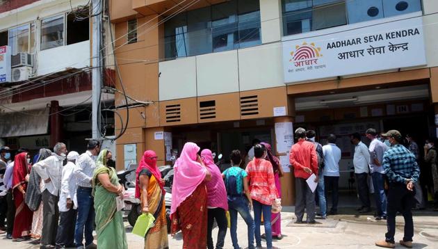 People stand in a queue outside an Aadhaar service centre to get their Aadhaar cards updated (File Photo/ANI)
