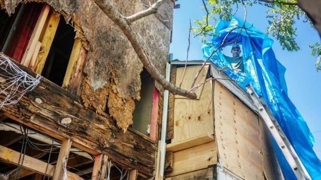 Steve Hebert replaces a tarp on the roof of his townhouse after Hurricane Delta swept through Lake Charles in Louisiana on October 10. As rains receded, residents dodged overturned cars on the roads, fallen trees, trudged through knee-deep waters to flooded homes with ruined floors and no power, in a bid to rebuild. (Kathleen Flynn / Reuters)