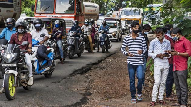 Commuters wearing masks and waiting at a traffic intersection in Kochi, Kerala amid the Covid-19 pandemic. (AP PHOTO.) Commuters wearing masks and waiting at a traffic intersection in Kochi, Kerala amid the Covid-19 pandemic. (AP PHOTO.)