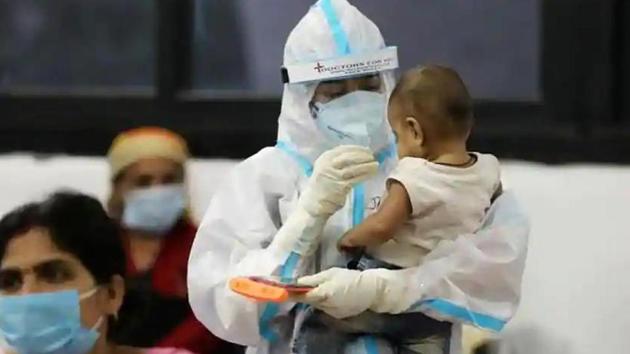 A medical worker in personal protective equipment (PPE) plays with a child of woman recovering inside a quarantine centre for the coronavirus disease (Covid-19) in New Delhi.(Reutters File Photo)