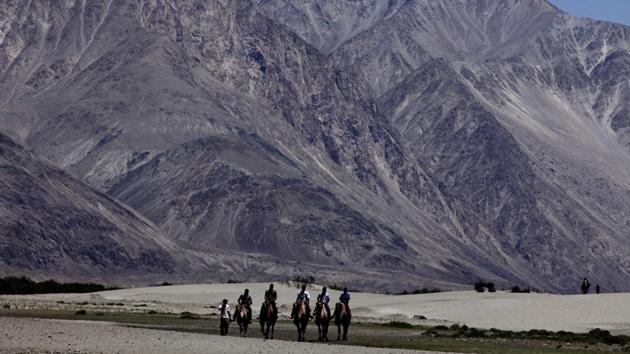 Tourists ride double hump camels at Nubra valley, in Ladakh, India. The Indian Army and the People’s Liberation Army have been locked in a border row for more than five months.(AP)