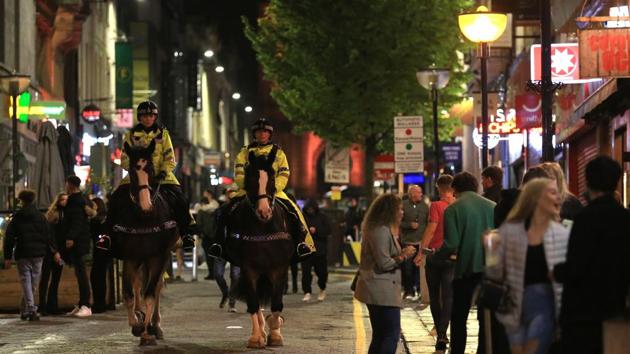 Police patrol as revellers enjoy a night out in the centre of Liverpool on October 10. Areas in the lowest tier will follow existing national restrictions, including a 10pm curfew on pubs and restaurants and a ban on more than six people gathering. In areas at high risk, members of different households are barred from meeting indoors. (Lindsey Parnaby / AFP)