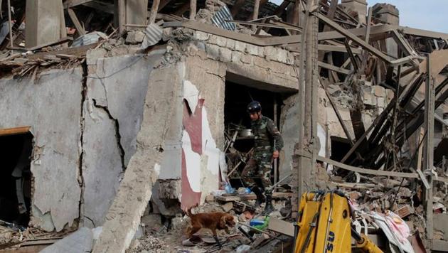A search and rescue dog searches for survivers at the blast site hit by a rocket during the fighting over the breakaway region of Nagorno-Karabakh in the city of Ganja, Azerbaijan (REUTERS/Umit Bektas)