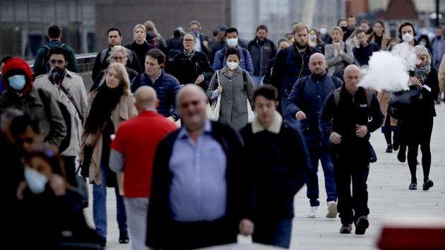 Commuters walk across London Bridge during the morning rush hour on Monday.(AP Photo)