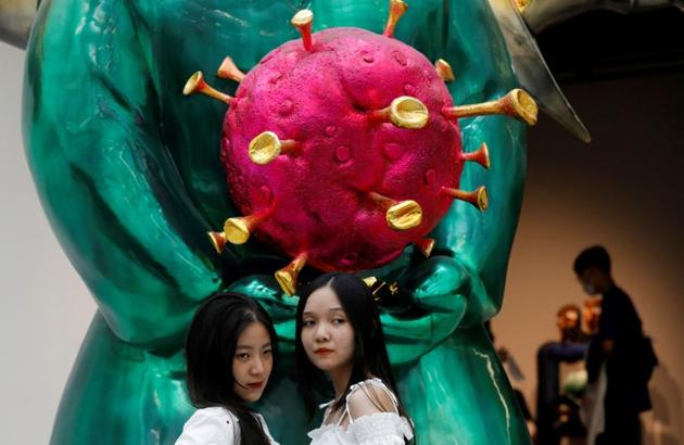 Visitors pose near the sculpture "Land Genie" by artist Pham Thai Binh. (REUTERS)