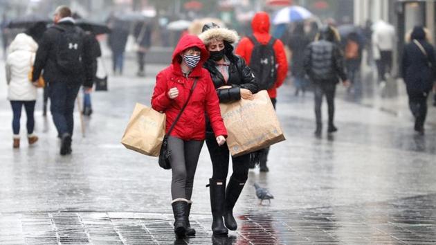 Commuters wearing face masks seen carrying shopping bags in Liverpool on October 12. Under the new measures, areas in England are classified at medium, high or very high risk, and placed under restrictions of varying severity. (Phil Noble / REUTERS)