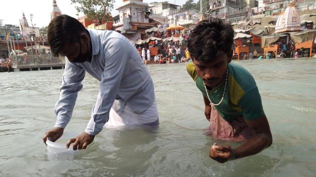 Coin pickers at work at Har-Ki-Pauri in Haridwar on Wednesday.(Rameshwar Gaur/HT photo)