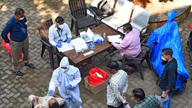 A BMC health worker collect swab samples at Vakola police station, in Santacruz east , Mumbai, on October 9. (Vijayanand Gupta/HT Photo) A BMC health worker collect swab samples at Vakola police station, in Santacruz east , Mumbai, on October 9. (Vijayanand Gupta/HT Photo)
