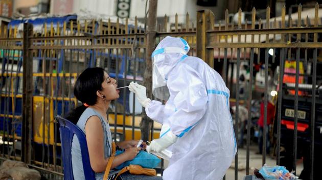 Bengaluru: A health worker wearing a PPE kit collects a sample from a woman for the COVID-19 Rapid Antigen Test, at a city market in Bengaluru, Wednesday, Oct. 7, 2020. (PTI) Bengaluru: A health worker wearing a PPE kit collects a sample from a woman for the COVID-19 Rapid Antigen Test, at a city market in Bengaluru, Wednesday, Oct. 7, 2020. (PTI)