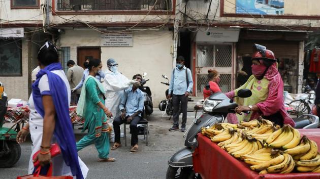 A healthcare worker wearing personal protective equipment (PPE) collects a swab sample from a man amidst the spread of the coronavirus disease at a weekly market in New Delhi. (REUTERS) A healthcare worker wearing personal protective equipment (PPE) collects a swab sample from a man amidst the spread of the coronavirus disease at a weekly market in New Delhi. (REUTERS)