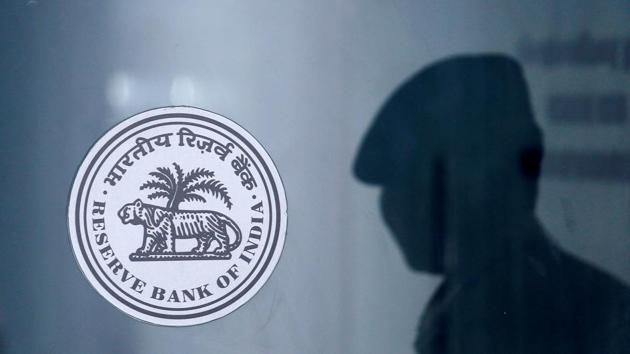 A security guard's reflection is seen next to the logo of the Reserve Bank Of India (RBI) at the RBI headquarters in Mumbai. (REUTERS) A security guard's reflection is seen next to the logo of the Reserve Bank Of India (RBI) at the RBI headquarters in Mumbai. (REUTERS)