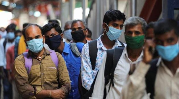 Passengers wearing protective face masks stand in a queue on a platform to get tested for Covid-19 at a railway station in New Delhi.(REUTERS PHOTO.)