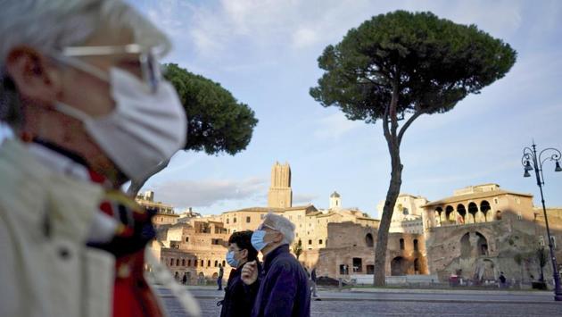 People wearing face masks seen walking on the streets in Rome, Italy on October 13. Italy has imposed new, tougher rules to control the resurgence, including an end to parties, amateur football matches and snacking at bars at night. (Andrew Medichini / AP)
