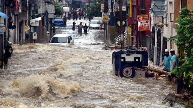 Floodwater gushes through a street following heavy rains at Falaknuma in Hyderabad on Wednesday. (PTI PHOTO.) Floodwater gushes through a street following heavy rains at Falaknuma in Hyderabad on Wednesday. (PTI PHOTO.)