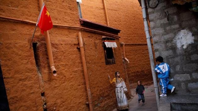 A woman in traditional clothes poses during a photoshoot as a boy watches in an alley in the old city of Lhasa, during a government organised tour of the Tibet Autonomous Region, China. (Reuters) A woman in traditional clothes poses during a photoshoot as a boy watches in an alley in the old city of Lhasa, during a government organised tour of the Tibet Autonomous Region, China. (Reuters)