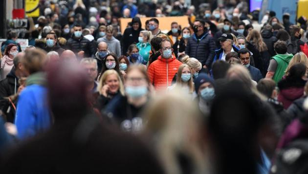 In an effort to fight the increasing cases in Germany, Chancellor Merkel has made face masks mandatory across many places. In Picture - People wearing protective face masks walk in the pedestrian area in the city of Dortmund, western Germany.(AFP)