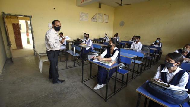 Students of Class 12 seated distantly during a class at a Government Senior Secondary School in Gurugram after authorities allowed schools to reopen voluntarily for classes 9 to 12 on October 15. After remaining shut for nearly seven months due to the lockdown in view of the coronavirus, cinemas, schools and religious services across several states were allowed to resume with restrictions. (Parveen Kumar / HT Photo)