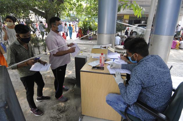 A health worker registers people for coronavirus test, at Sector 30 District Hospital, in Noida (Photo by Sunil Ghosh / Hindustan Times)