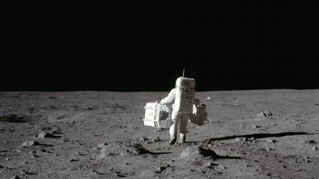 In this July 20, 1969 photo made available by NASA, lunar module pilot Buzz Aldrin carries a seismic experiments package in his left hand and the Laser Ranging Retroreflector to the deployment area on the surface of the moon at Tranquility Base. On Tuesday, Oct. 13, 2020, NASA released a set of guidelines for its Artemis moon-landing program, based on the 1967 Outer Space Treaty and other agreements.(AP)