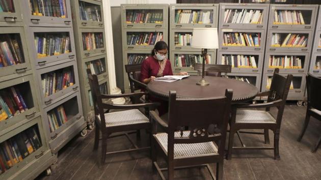 A woman reads a book at the State Central Library which reopened in Mumbai on October 15. A few states resumed classes from September 21, while they remain suspended in several states and UTs including capital Delhi as well as the worst affected states of Maharashtra, Andhra Pradesh and Karnataka. (Rajanish Kakade / AP)