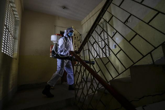 A civic staff in protective suit disinfects the staircase of an apartment where one of the residents tested positive for the coronavirus disease (Covid-19) in Kolkata in this file photo. (AP Photo) A civic staff in protective suit disinfects the staircase of an apartment where one of the residents tested positive for the coronavirus disease (Covid-19) in Kolkata in this file photo. (AP Photo)