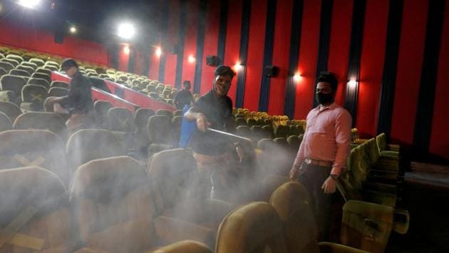 Workers sanitize a screening hall at City Gold cinemas in Ahmedabad on October 15. Cinemas are allowed to operate with 50% occupancy so as to maintain adequate physical distance between people. Not only on seats, floor marking will be done at box office counters too to ensure social distancing. (Amit Dave / REUTERS)
