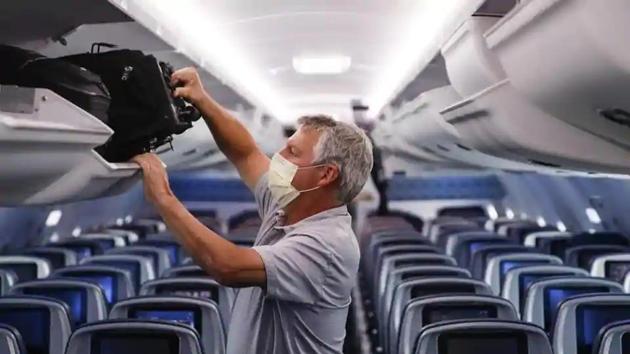 A passenger wears personal protective equipment on a Delta Airlines flight after landing at Minneapolis−Saint Paul International Airport, in Minneapolis. (AP File Photo) A passenger wears personal protective equipment on a Delta Airlines flight after landing at Minneapolis−Saint Paul International Airport, in Minneapolis. (AP File Photo)