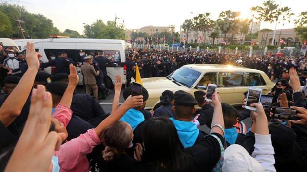 A car in the royal motorcade with Queen Suthida and Prince Dipangkorn drives past a group of anti-government demonstrators in front of the Government House in Bangkok on October 14. A video circulated widely on social media showing members of a small crowd heckling a royal motorcade. The incident has shocked Thais because by tradition and law - members of the royal family are treated with the utmost respect, AP reported (Reuters)