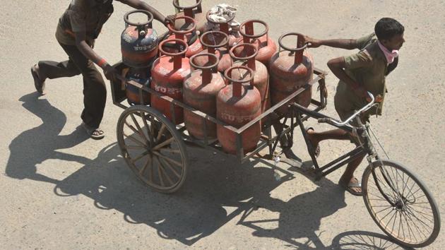 Delivery persons transporting LPG gas cylinders in a rickshaw cart in Patna (Photo by Parwaz Khan / Hindustan Times)