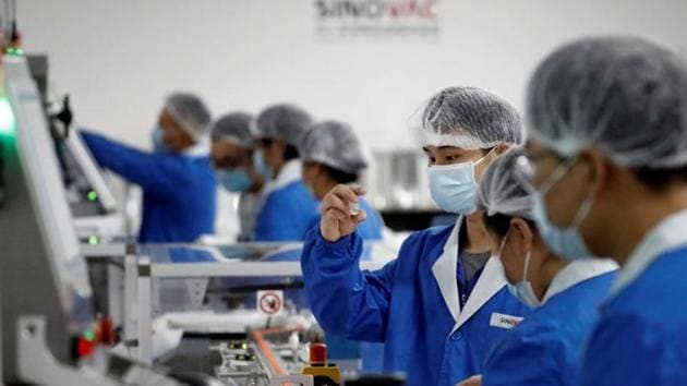 People work in the packaging facility of Chinese vaccine maker Sinovac Biotech, developing an experimental coronavirus disease (COVID-19) vaccine, during a government-organized media tour in Beijing, China.(REUTERS)