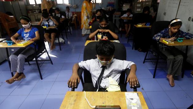 Students watch online lectures on mobile phones, inside a digital mobile education library, initiated to provide mobile phones to chidren who have no access to them for their education classes amidst the spread of the coronavirus disease in Mumbai. (REUTERS) Students watch online lectures on mobile phones, inside a digital mobile education library, initiated to provide mobile phones to chidren who have no access to them for their education classes amidst the spread of the coronavirus disease in Mumbai. (REUTERS)