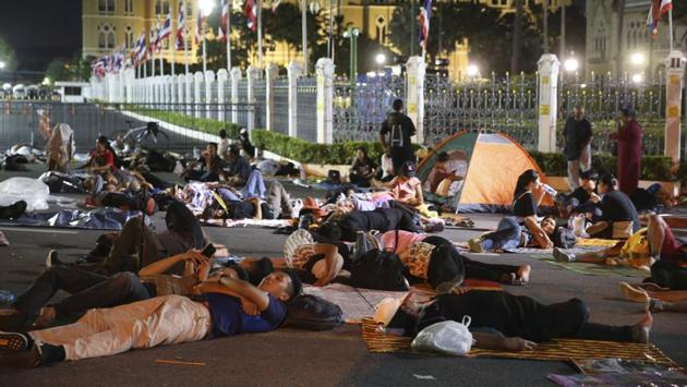 Protesters sleep in front of Government house during demonstration in Bangkok on October 15. Police announced on October 16 that they would block roads leading to Bangkok’s Rajprasong intersection, where last night’s protest was held, after protesters called on supporters to mass again while protesting activities continued well past midnight, AP reported. (Rapeephat Sitichailapa / AP)