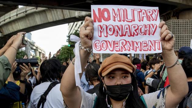 A pro-democracy protester holds a banner during a protest in Bangkok on October 15. Meanwhile, atleast 51 people have been arrested since October 13 in connection with the protests, a legal aid group called Thai Lawyers for Human Rights told AP. (Gemunu Amarasinghe / AP)