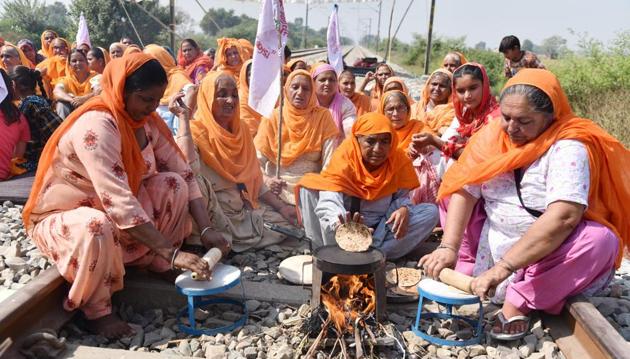 Women making chapatis on traditional stoves on railway track as part of the 'Rail Roko' protest against the new agriculture laws at Devi Dass Pura in Amritsar on Saturday.(Sameer Sehgal/HT)