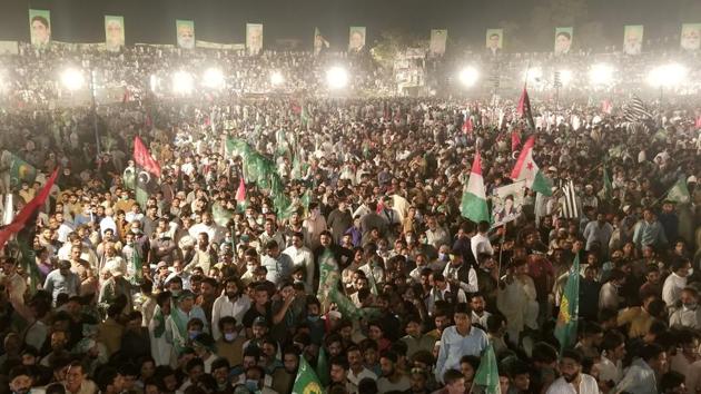 Supporters of the Pakistan Democratic Movement (PDM), an alliance of opposition parties, wave flags as they listen to their leaders during an anti-government protest rally in Gujranwala on October 16.(REUTERS)