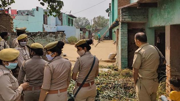 Police personnel stand guard as CBI officials (not visible in picture) investigate the Hathras case.(PTI Photo)