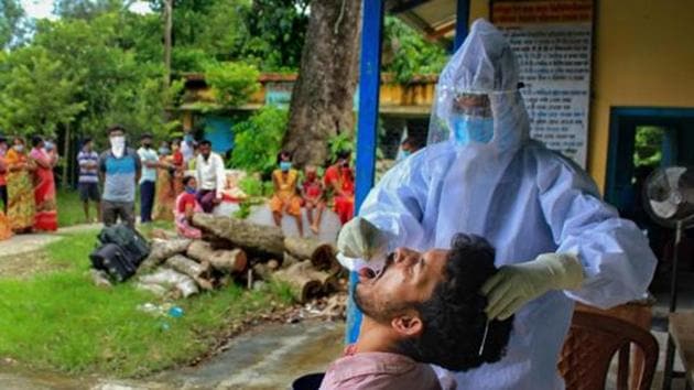 A health worker collects swab sample of a villager for Covid-19 test in Manipur. (PTI) A health worker collects swab sample of a villager for Covid-19 test in Manipur. (PTI)