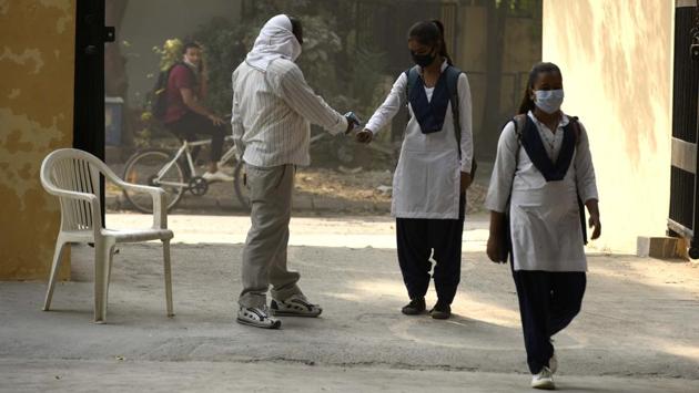 Students undergo thermal screening while entering a Government Senior Secondary School (GSSS) in Gurugram on October 15. According to daily data released by the Union health ministry, India recorded the lowest number of daily cases this week on October 13 with 55,342 infections. (Parveen Kumar / HT Photo)