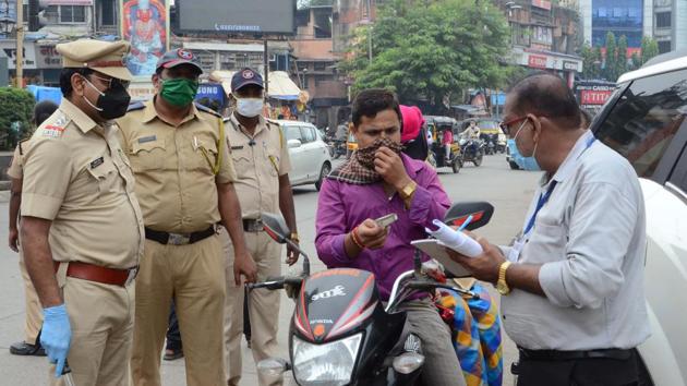 A Kalyan Dombivli Municipal Corporation employee issues a challan to a commuter for not wearing face mask in Kalyan on October 15. The government has however asked citizens to exercise caution as elections, festive season and winters pose a risk and can lead to a surge in the number of cases of the coronavirus disease. (Rishikesh Choudhary / HT Photo)