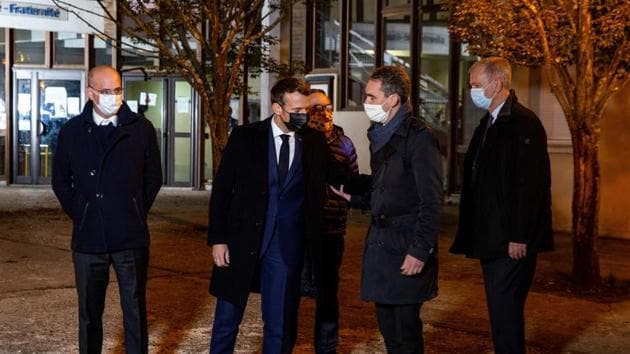 French President Emmanuel Macron and French Education Minister Jean-Michel Blanquer talk with officials as they visit the scene of a stabbing attack in the Conflans-Sainte-Honorine suburb of Paris, France.(REUTERS)