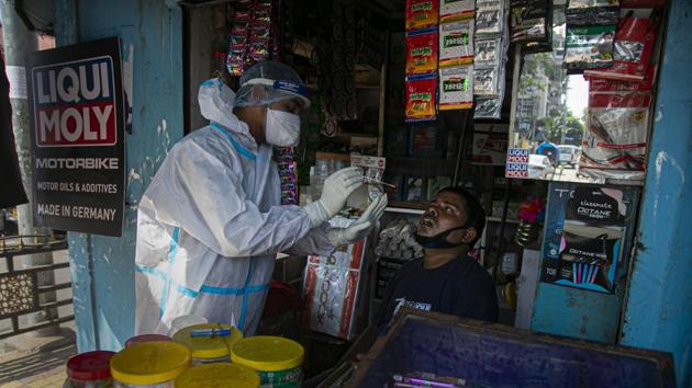 A health worker takes a nasal swab sample of a shopkeeper during random testing for Covid-19 in a market in Guwahati, Assam on October 16, 2020.(AP Photo)