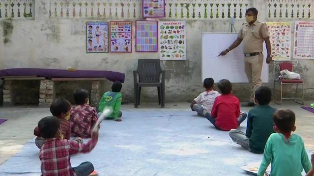 Than Singh, a constable with the Delhi Police teaching some kids.(ANI) Than Singh, a constable with the Delhi Police teaching some kids.(ANI)