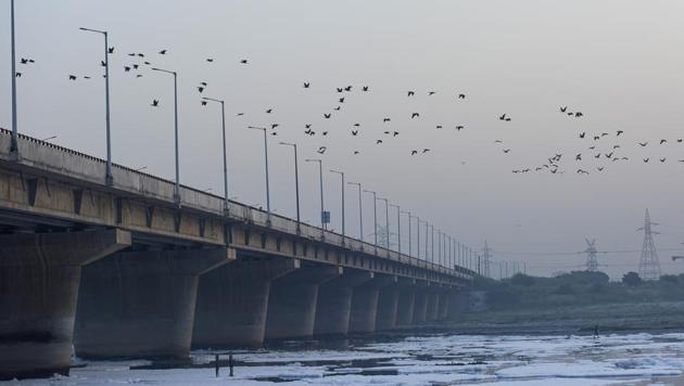 Birds fly over the heavily polluted waters of the Yamuna River, at Kalindi Kunj in New Delhi. (Biplov Bhuyan/HT PHOTO)