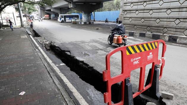 A road damaged due to flash floods at Katraj in Pune on October 16. Prime Minister Narendra Modi pledged centre’s assistance to the flood relief work in Maharashtra and expressed his concern and condolences to the affected in a tweet on October 16. (Rahul Raut / HT Photo) 