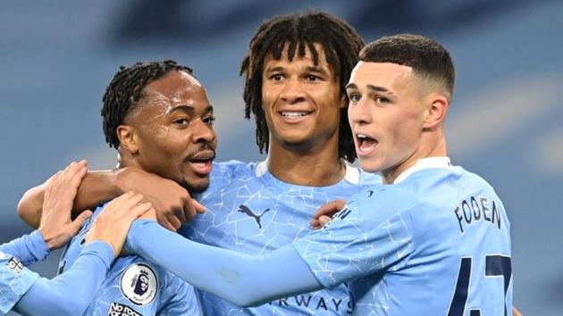 Manchester City's Raheem Sterling celebrates scoring their first goal with Phil Foden and Nathan Ake.(Pool via REUTERS)