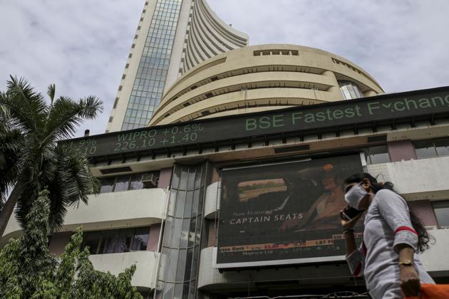 A pedestrian wearing a protective mask walks past the Bombay Stock Exchange (BSE) building in Mumbai in this file photo. (Bloomberg) A pedestrian wearing a protective mask walks past the Bombay Stock Exchange (BSE) building in Mumbai in this file photo. (Bloomberg)