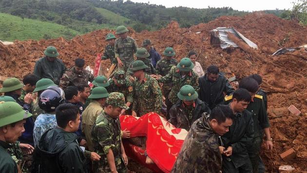 This picture taken on October 18, 2020 and released by the Vietnam News Agency on October 18, 2020 shows military personnel carrying a body recovered from the site of a landslide in central Vietnam's Quang Tri province. (Photo by STR / Vietnam News Agency / AFP)(AFP)
