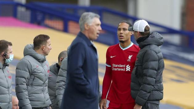 Liverpool's manager Jurgen Klopp, right, checks on Liverpool's Virgil van Dijk, second right, as he leaves the match with an injury during the English Premier League soccer match between Everton and Liverpool.(AP)