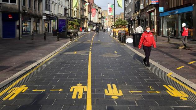 A commuter walks on a street with social distancing markers printed on it in Cardiff, Wales on October 19. It took just 32 days to go from 30 million global cases to 40 million, compared with the 38 days it took to get from 20 to 30 million. It took three months to reach 10 million cases from when the first cases were reported in Wuhan, China, in early January this year. (Rebecca Naden / REUTERS)